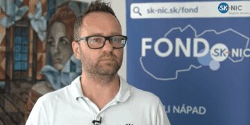 Muž pred bannerom s logom Fondu SK-NIC