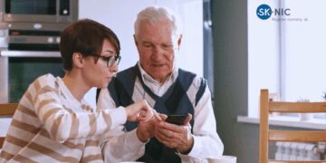 Mladá žena a starší muž s mobilom, podpora projektov z Fondu SK-NIC